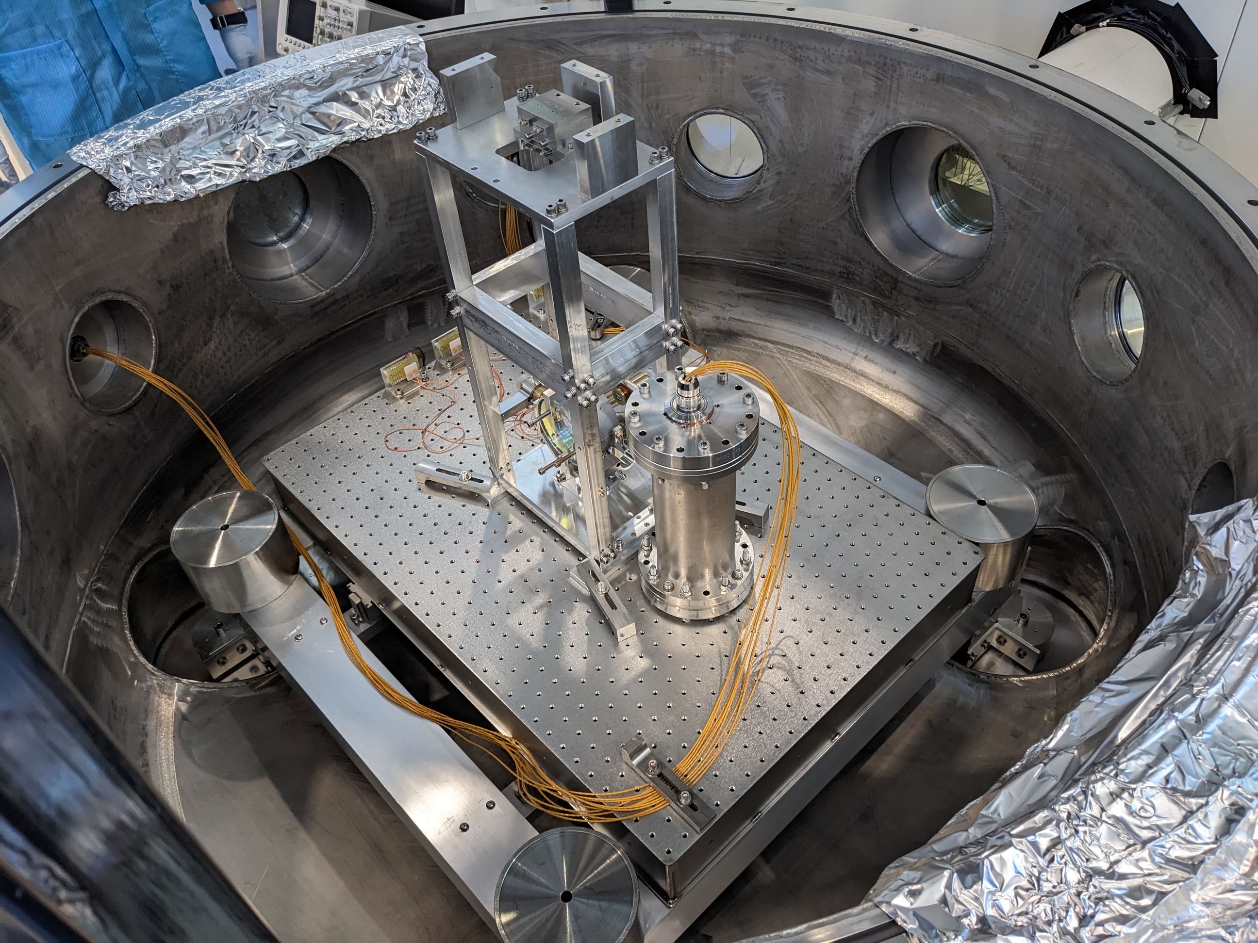 A test mass (mirror) suspended in a LIGO small optic suspension, next to a seismometer